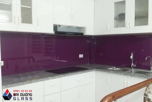 Kính ốp bếp màu tím, tủ bếp trắng, mặt đá hoa cương
