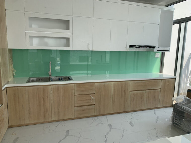 Tủ trên trắng, kính ốp bếp màu xanh ngọc và tủ dưới vân gỗ