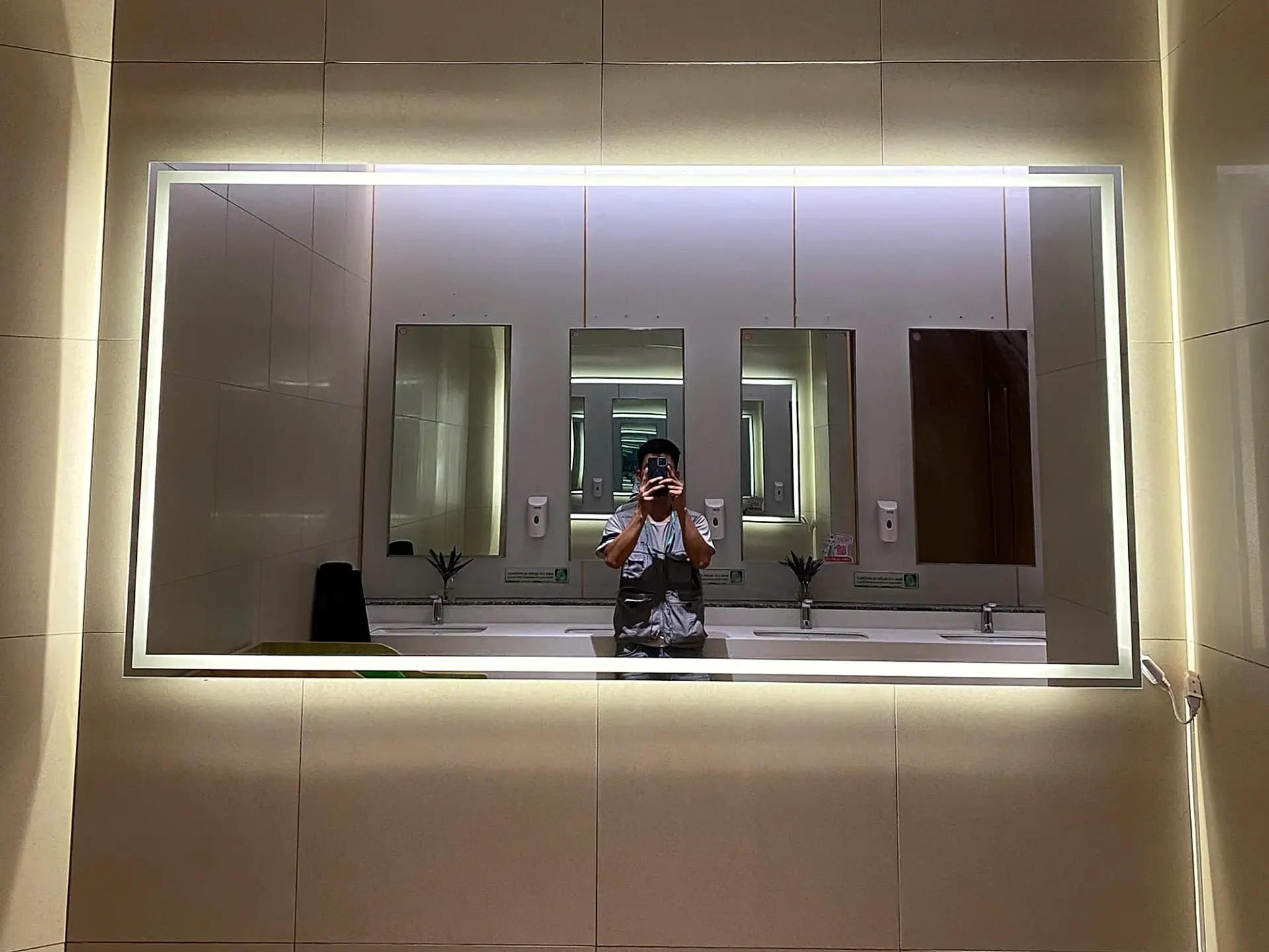 Gương LED chữ nhật khổ lớn viền sáng và hắt sau trong khu vệ sinh TTTM Parc Mall, phản chiếu dãy lavabo đối diện, công trình Kính Đại Dương